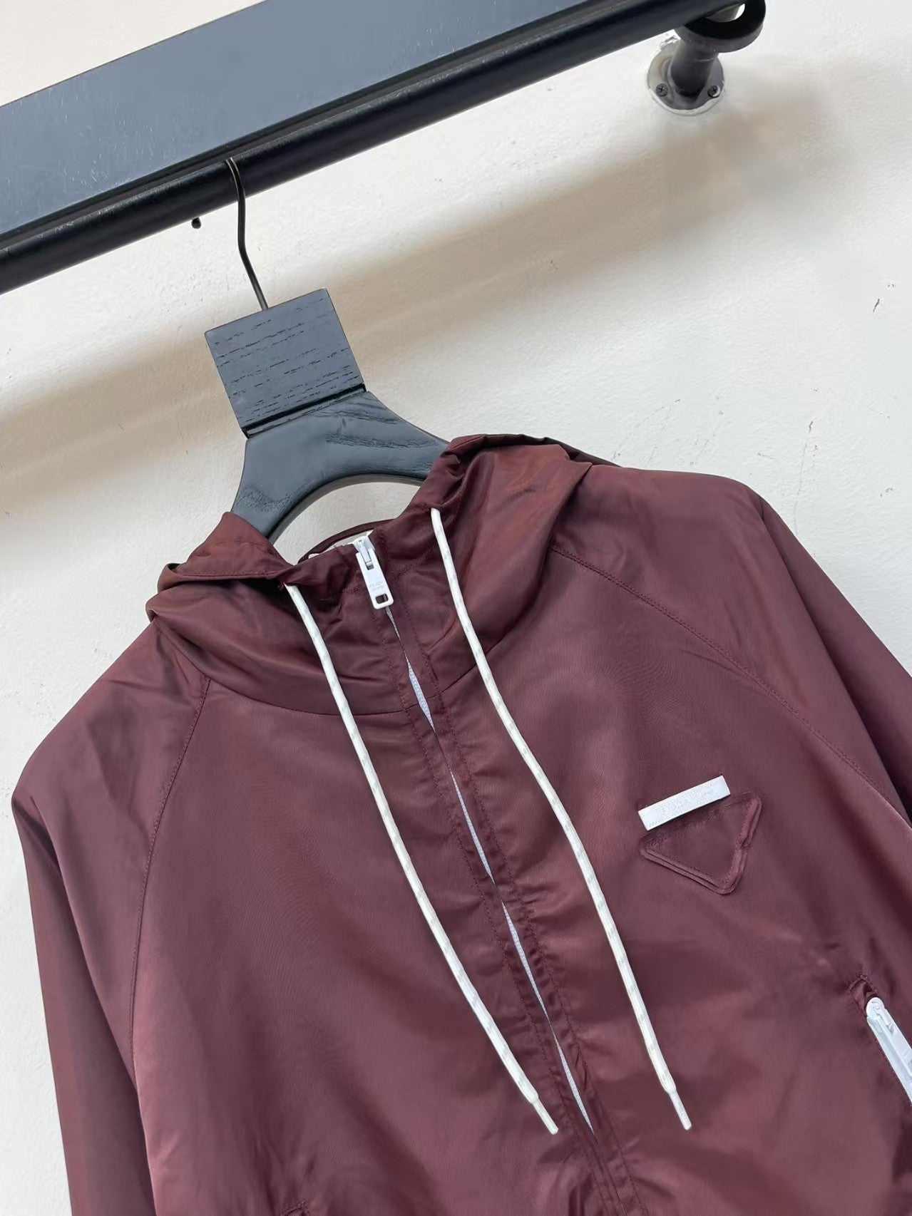 Veste à capuche courte et légère avec logo triangulaire